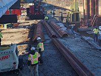 Workers oversee cofferdam instruction.